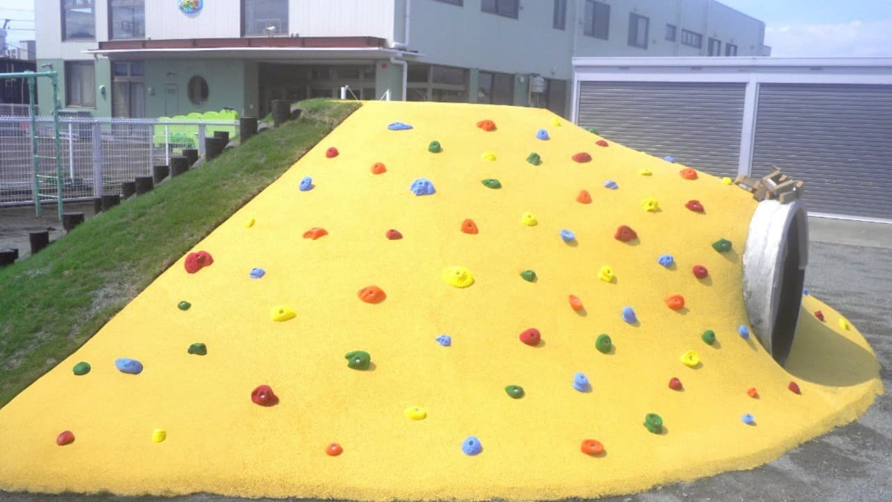 保育園の園庭にあるトンネル付き屋外遊具の写真